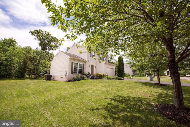  - view of home's exterior with an attached garage and a yard