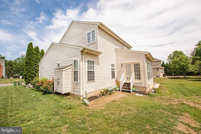  - rear view of property with entry steps and a yard