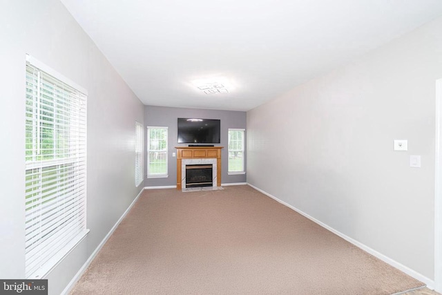  - unfurnished living room featuring carpet floors and a tile fireplace