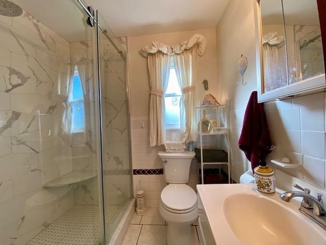full bathroom with tile walls, a marble finish shower, toilet, and tile patterned floors