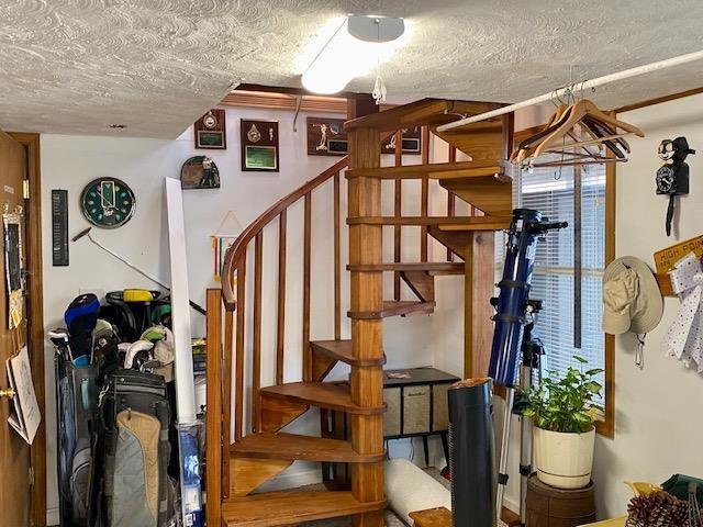 staircase with a textured ceiling