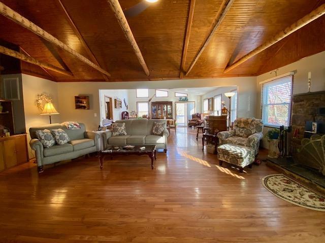 living room featuring wooden ceiling, wood finished floors, beamed ceiling, and high vaulted ceiling