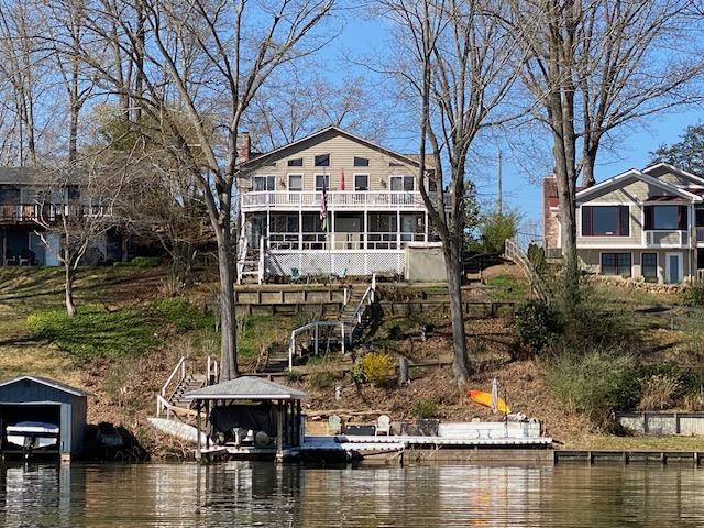 rear view of property featuring a water view and stairs