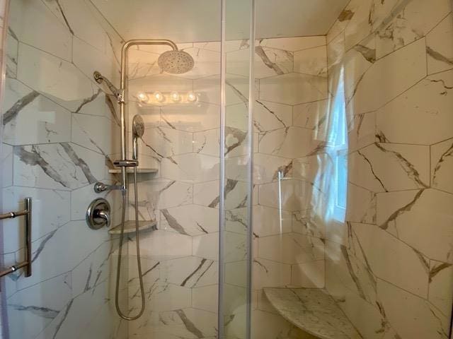 full bathroom featuring a marble finish shower