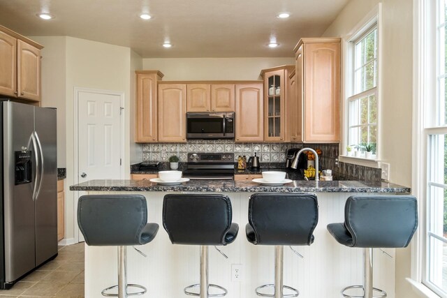 11 Tradewind Cir, Fishersville, VA 22939 - kitchen with appliances with stainless steel finishes, light brown cabinetry, a peninsula, glass insert cabinets, and recessed lighting