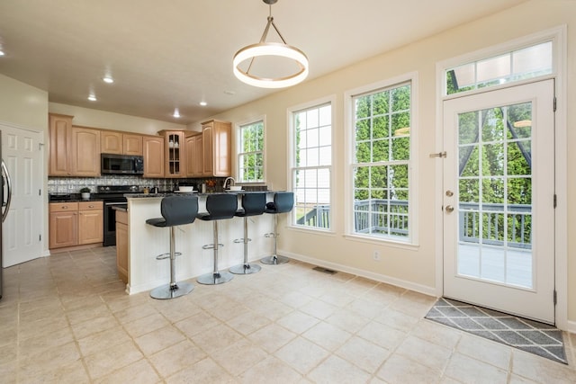 11 Tradewind Cir, Fishersville, VA 22939 - kitchen featuring black / electric stove, stainless steel microwave, backsplash, dark countertops, and a breakfast bar area