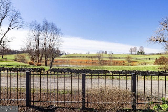 view of yard with fence and a rural view