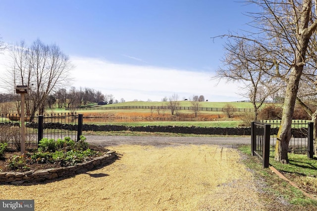 view of yard featuring a rural view and fence