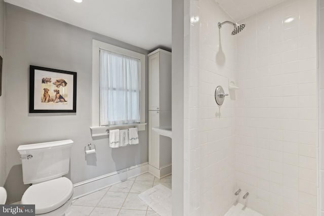 bathroom featuring a tile shower, toilet, marble look tiles, baseboards, and recessed lighting