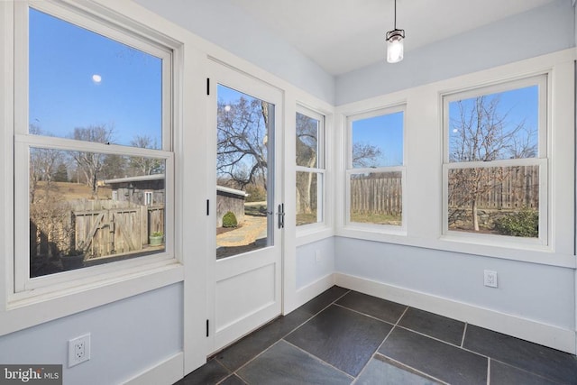 unfurnished sunroom with tile patterned flooring and baseboards