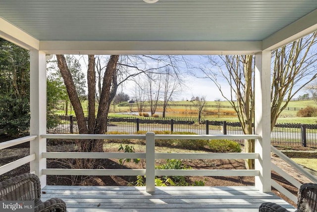 wooden terrace featuring fence and a water view