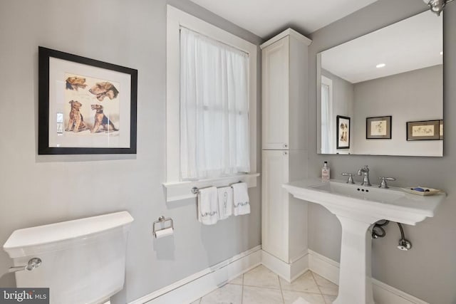 bathroom featuring baseboards, tile patterned floors, and toilet