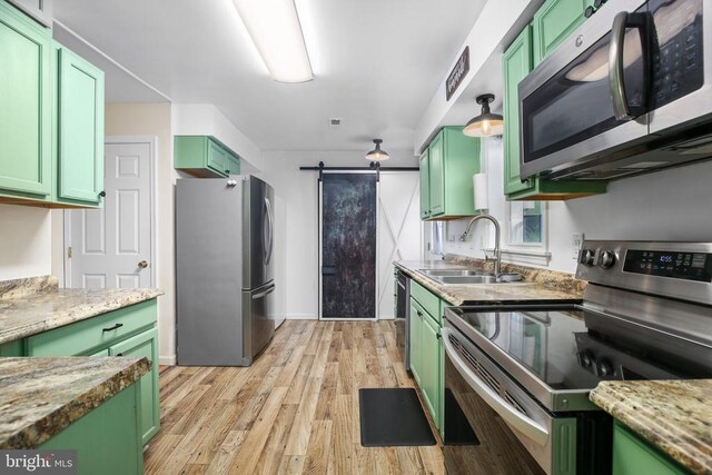 167 Fairview Rd, Louisa, VA 23093 - kitchen featuring green cabinetry, appliances with stainless steel finishes, a barn door, and light wood finished floors