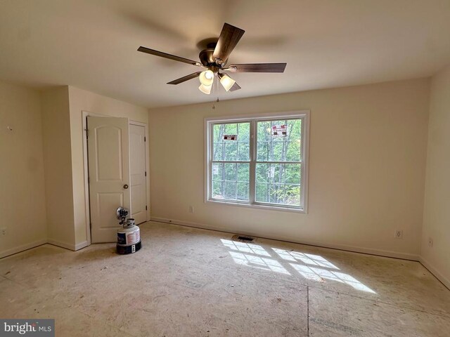 spare room featuring a ceiling fan and baseboards