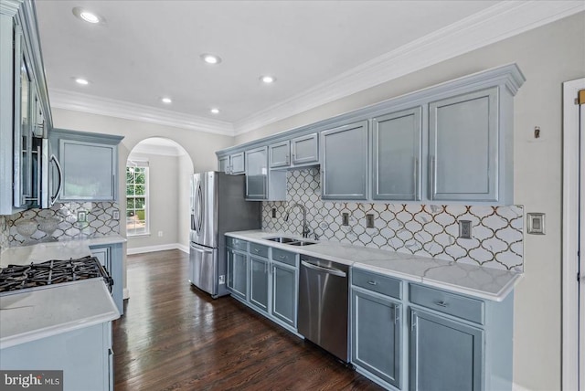 6903 Quitman Dr, Fredericksburg, VA 22407 - kitchen with appliances with stainless steel finishes, a sink, arched walkways, backsplash, and dark wood finished floors