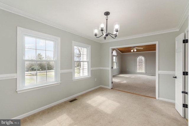 unfurnished dining area with a chandelier, crown molding, carpet, plenty of natural light, and baseboards