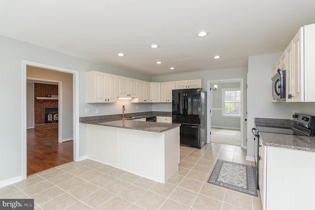 kitchen with black appliances, a sink, baseboards, recessed lighting, and light tile patterned floors
