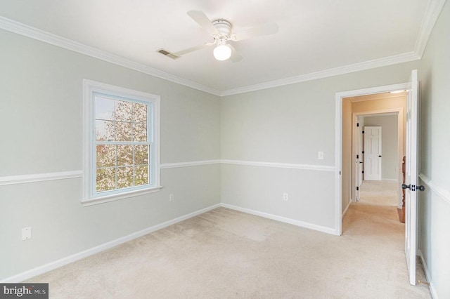 unfurnished room featuring light colored carpet, ornamental molding, a ceiling fan, and baseboards