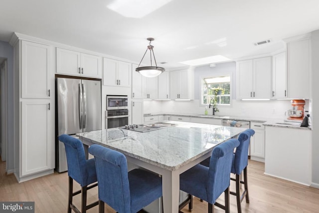 1550 Clover Dr, Fredericksburg, VA 22407 - kitchen with appliances with stainless steel finishes, white cabinets, a kitchen breakfast bar, and light stone counters