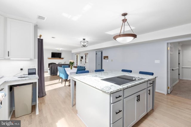 1550 Clover Dr, Fredericksburg, VA 22407 - kitchen featuring black electric cooktop, light wood-style flooring, a center island, and backsplash