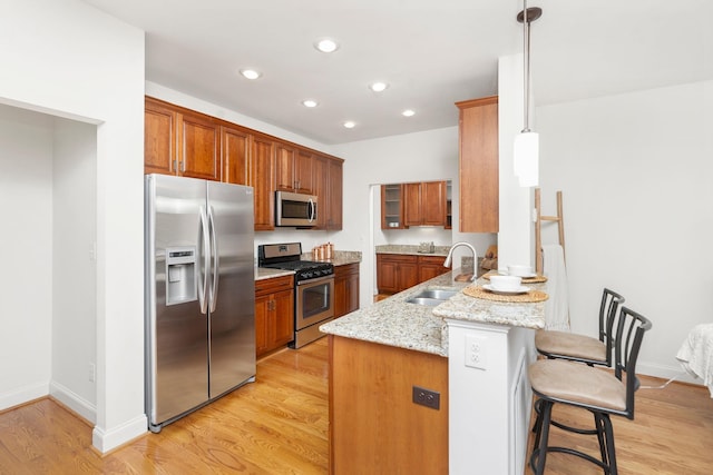 325 Petros Dr, Waynesboro, VA 22980 - kitchen featuring stainless steel appliances, a sink, a peninsula, a breakfast bar area, and brown cabinets