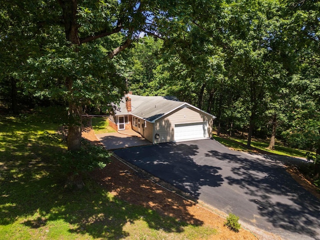 2035 Lee Jackson Hwy, Staunton, VA 24401 - view of front facade with driveway, an attached garage, a chimney, a wooded view, and a front yard