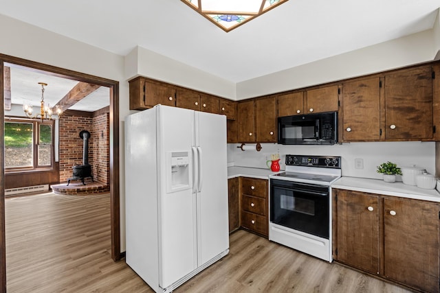 2035 Lee Jackson Hwy, Staunton, VA 24401 - kitchen with white refrigerator with ice dispenser, black microwave, range with electric cooktop, baseboard heating, and a wood stove