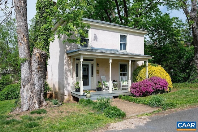 view of front facade featuring covered porch and stucco siding