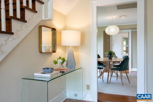 hallway with wood finished floors, stairs, and baseboards