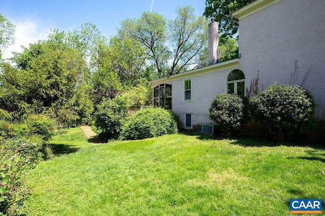 view of grassy yard featuring central AC unit