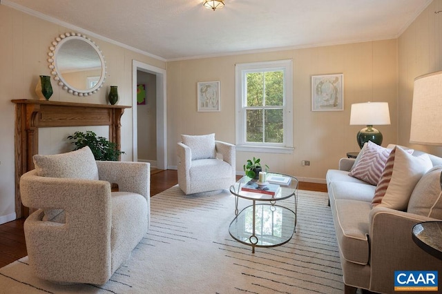 living area with crown molding, wood finished floors, and baseboards