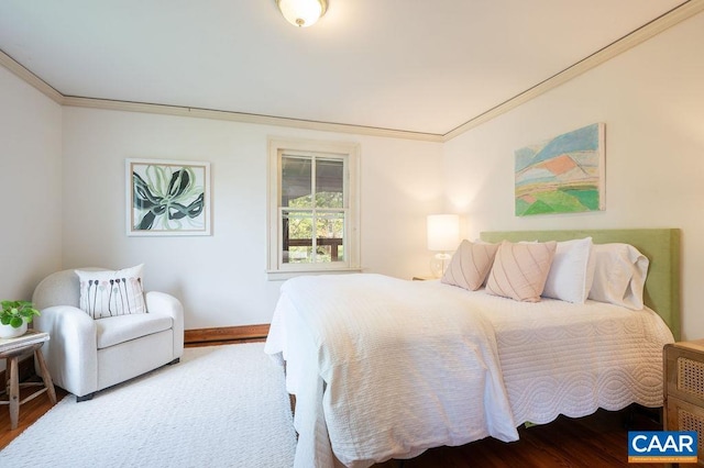 bedroom with wood finished floors, ornamental molding, and baseboards