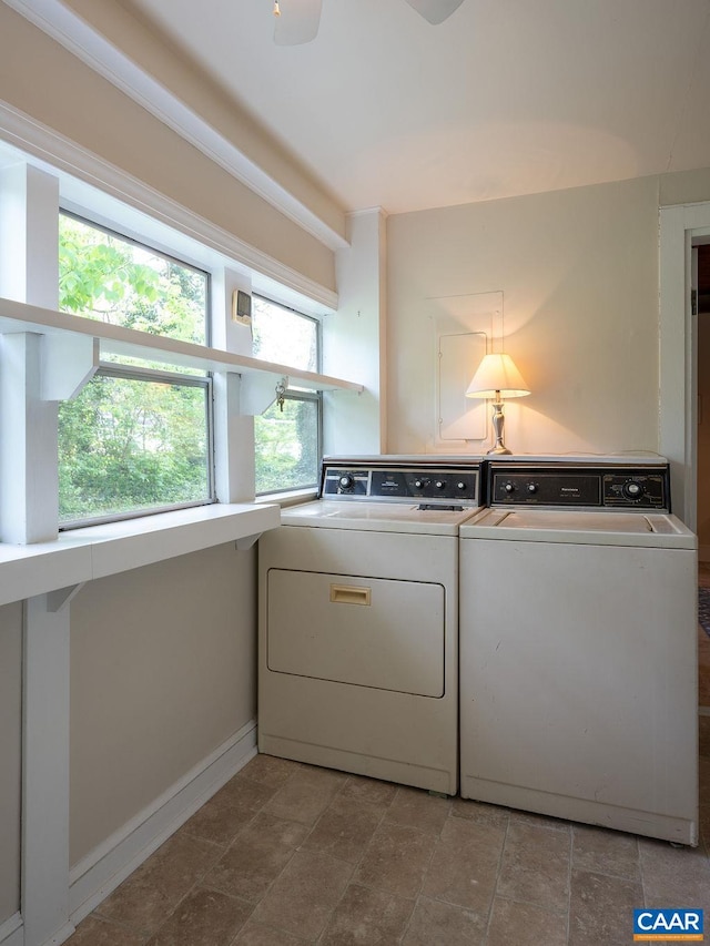 laundry area featuring washer and clothes dryer, stone finish flooring, and baseboards