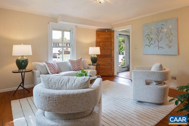 sitting room with crown molding, wood-type flooring, and baseboards