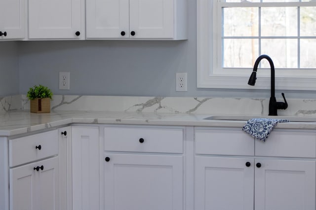 kitchen with a sink and white cabinetry