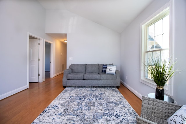 living area with plenty of natural light, wood finished floors, and baseboards