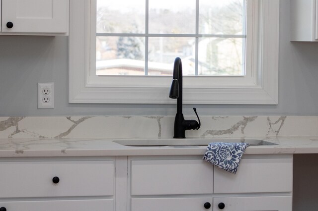 interior details featuring white cabinetry and a sink