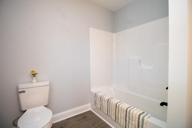 bathroom with baseboards, toilet, and wood finished floors