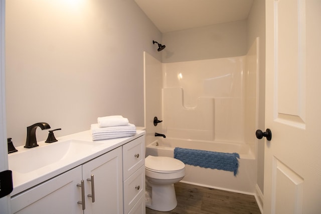bathroom featuring vanity, toilet, wood finished floors, and shower / bathing tub combination