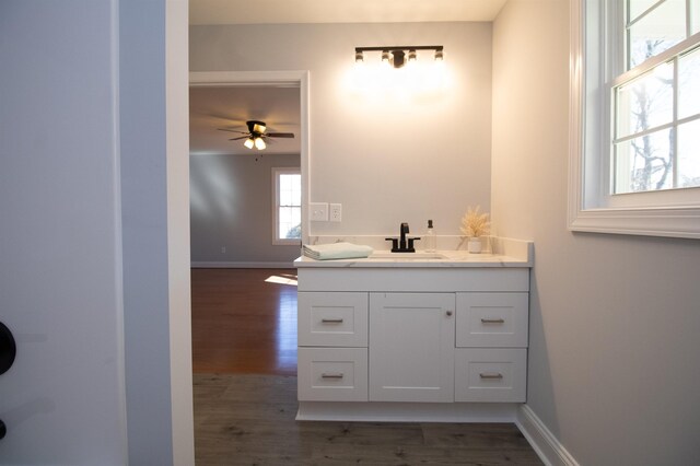 bathroom with vanity, baseboards, a ceiling fan, and wood finished floors