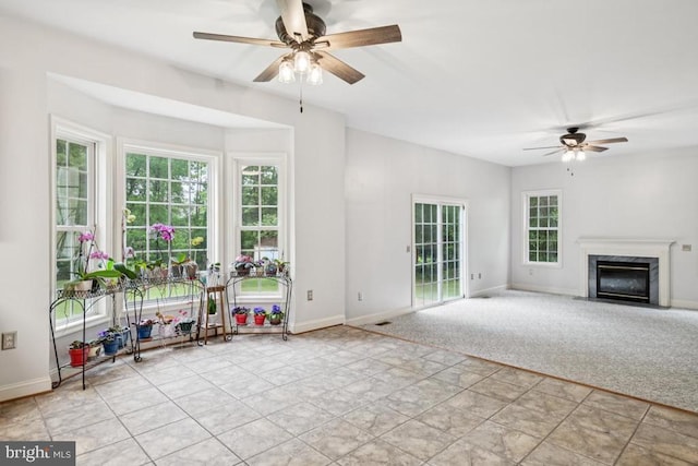  - unfurnished living room featuring a ceiling fan and a fireplace