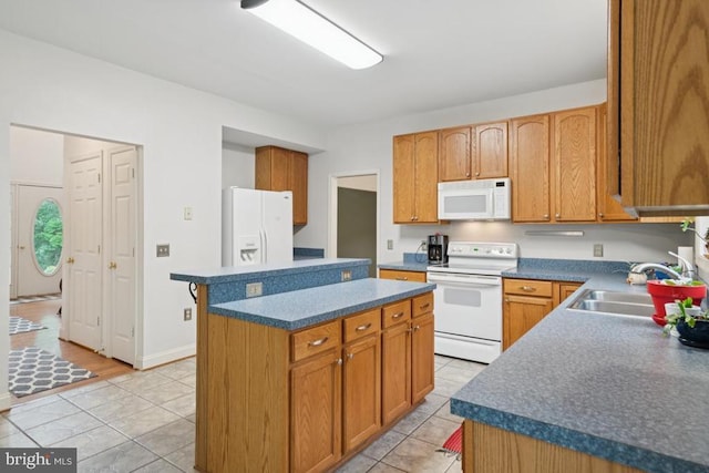  - kitchen featuring white appliances, a kitchen island, light tile patterned floors, and dark countertops