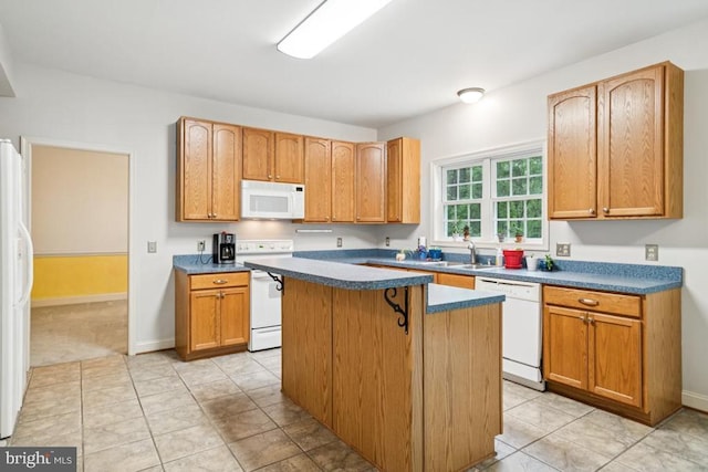  - kitchen featuring white appliances, a kitchen island, light tile patterned floors, and dark countertops
