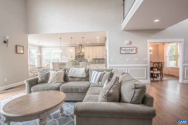 living area featuring wood finished floors, a high ceiling, and recessed lighting