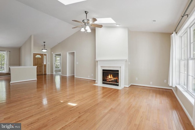 200 Saylers Creek Rd, Locust Grove, VA 22508 - unfurnished living room with a skylight, light wood finished floors, a fireplace with flush hearth, a ceiling fan, and high vaulted ceiling