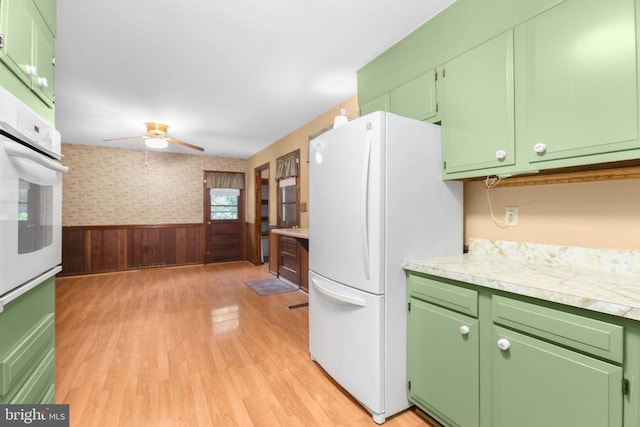 8305 Old Plank Rd, Fredericksburg, VA 22407 - kitchen with a ceiling fan, light wood finished floors, a wainscoted wall, white appliances, and light countertops