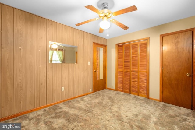 8305 Old Plank Rd, Fredericksburg, VA 22407 - unfurnished bedroom featuring carpet flooring, ceiling fan, two closets, and wood walls