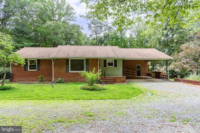 8305 Old Plank Rd, Fredericksburg, VA 22407 - ranch-style house featuring an attached carport, gravel driveway, a front yard, and brick siding