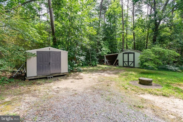 8305 Old Plank Rd, Fredericksburg, VA 22407 - view of yard with a storage shed, a fire pit, and a wooded view
