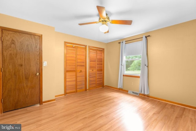 8305 Old Plank Rd, Fredericksburg, VA 22407 - unfurnished bedroom featuring light wood-type flooring, two closets, and a ceiling fan